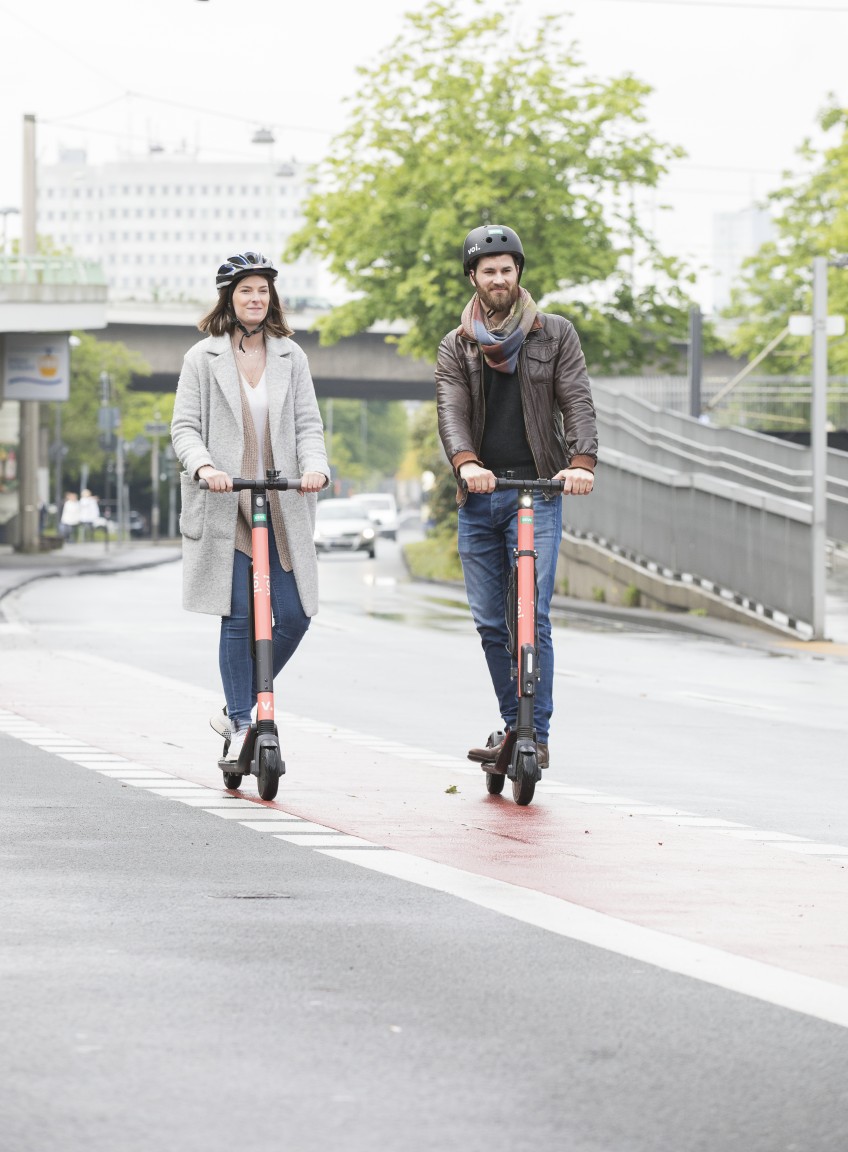 Pressemitteilung E-Scooter - Mann und Frau mit E-Scooter auf Radweg