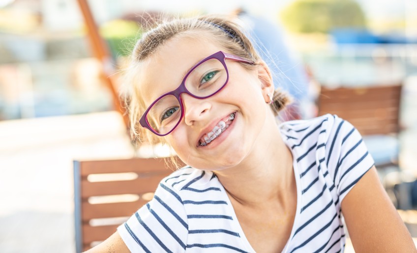 Pressemitteilung Zahnpangen für Kinder: lachendes Mädchen mit Zahnspange