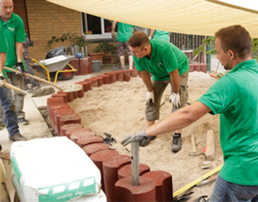 Schlagzeilen - drei Mitarbeiter bauen eine Mauer