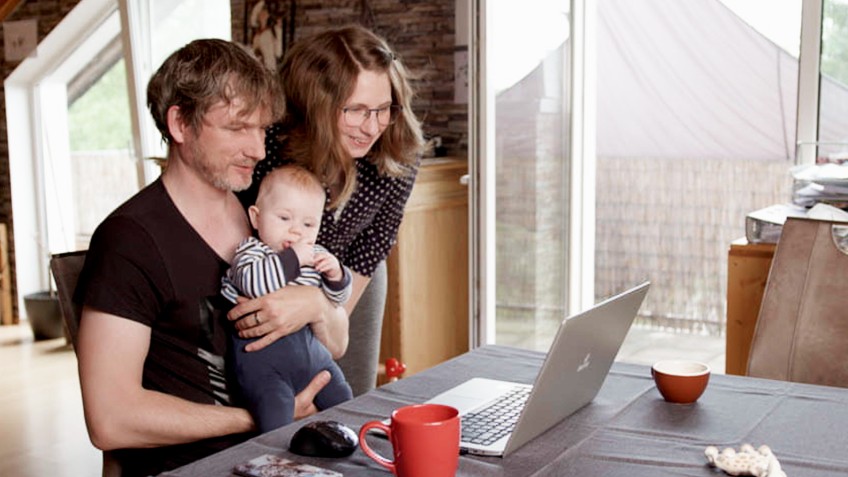 Schlagzeile - Familie mit Säugling vor Laptop