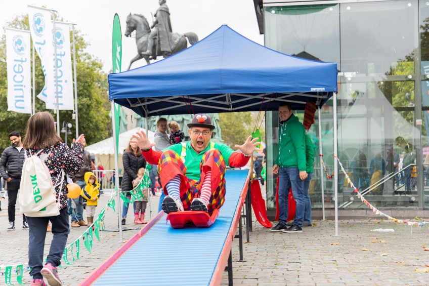 Clown rutscht auf der DEVK-Rollenrutsche