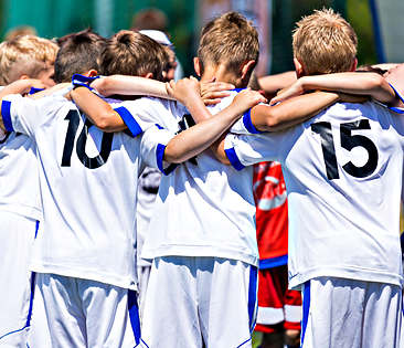 Vereinshaftpflichtversicherung - junge Fußballer im Schulterkreis