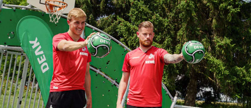 DEVK-Waterballoon-Challenge: Timo Horn und Timo Hübers halten DEVK-Fußbälle in den Händen