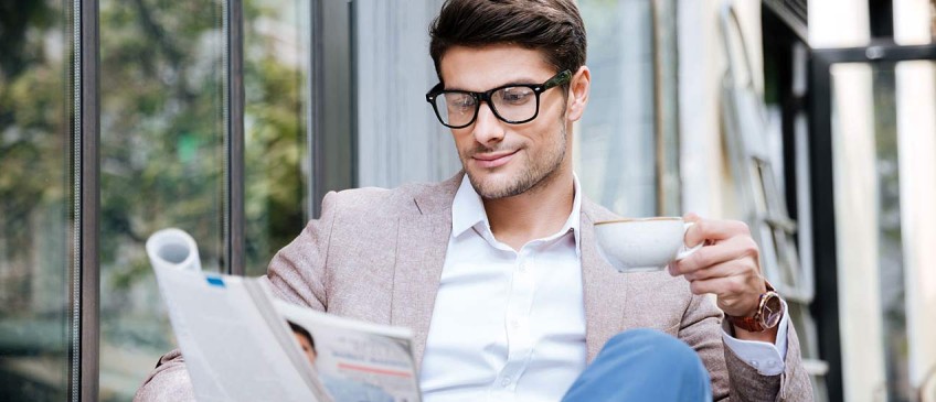 Presse - Mann liest Zeitung im Café