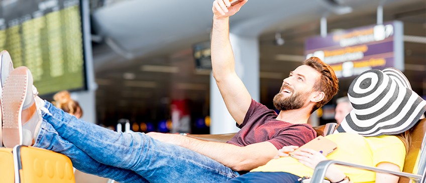 Ratgeber Urlaub - Paar wartet am Flughafen