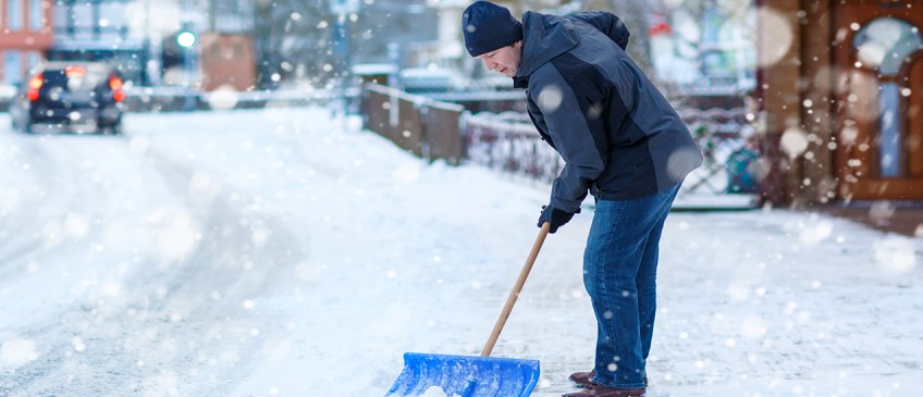 Winterdienst - Mann schippt Schnee