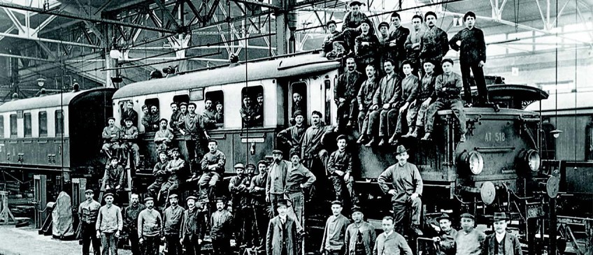 Unternehmensgeschichte - Eisenbahner sitzen auf Zug
