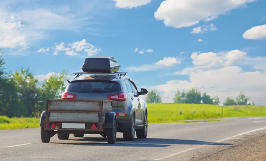 Anhänger Versicherung - Auto mit Anhänger auf Landstraße