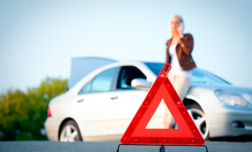 Schutzbrief Auto Plus - Warndreieck steht weißem Auto