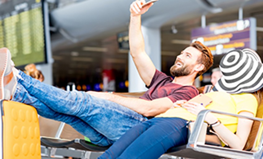 Ratgeber Urlaub - Paar wartet am Flughafen