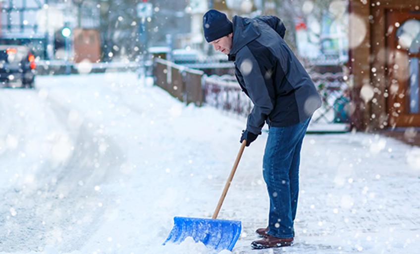 Winterdienst - Mann schippt Schnee