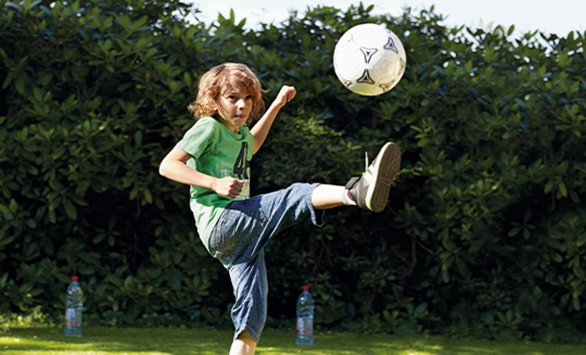 Kinder-Unfallversicherung - Vater und Sohn spielen Fußball