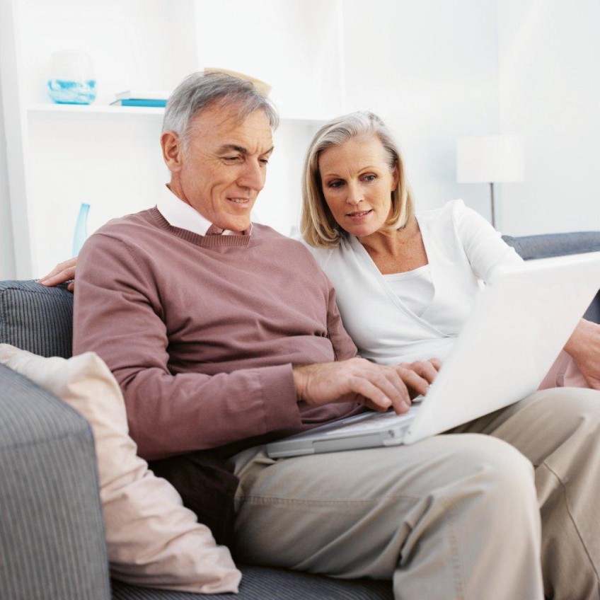 Pressemitteilung Testamentserstellung - Älteres Paar mit Laptop auf der Couch
