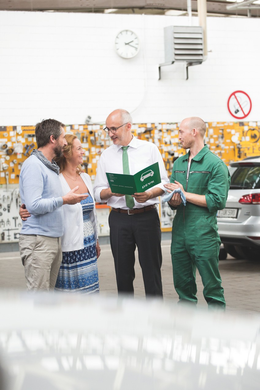 Pressemitteilung Kfw-Werkstadtbindung - Pärchen mit DEVK-Berater und Monteur in Autowerkstatt