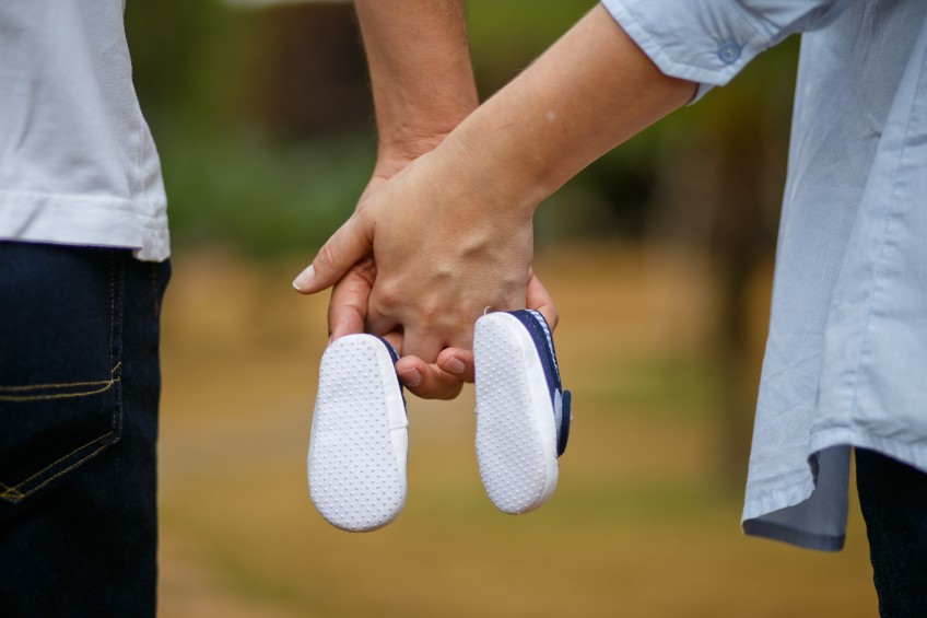 Pressemitteilung Familienumfrage - Paar hält Babyschuhe in den Händen