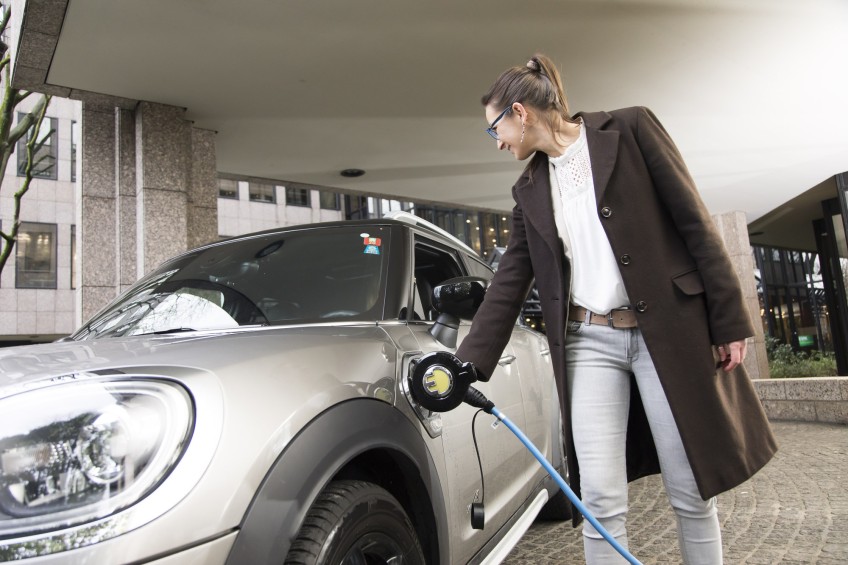 Pressemitteilung: Frau lädt Elektroauto auf