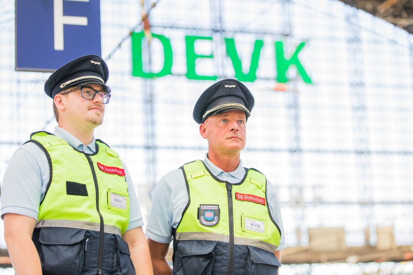 Pressemitteilung Beitragsrückerstattung: DB-Sicherheit-Personal vor DEVK-Logo