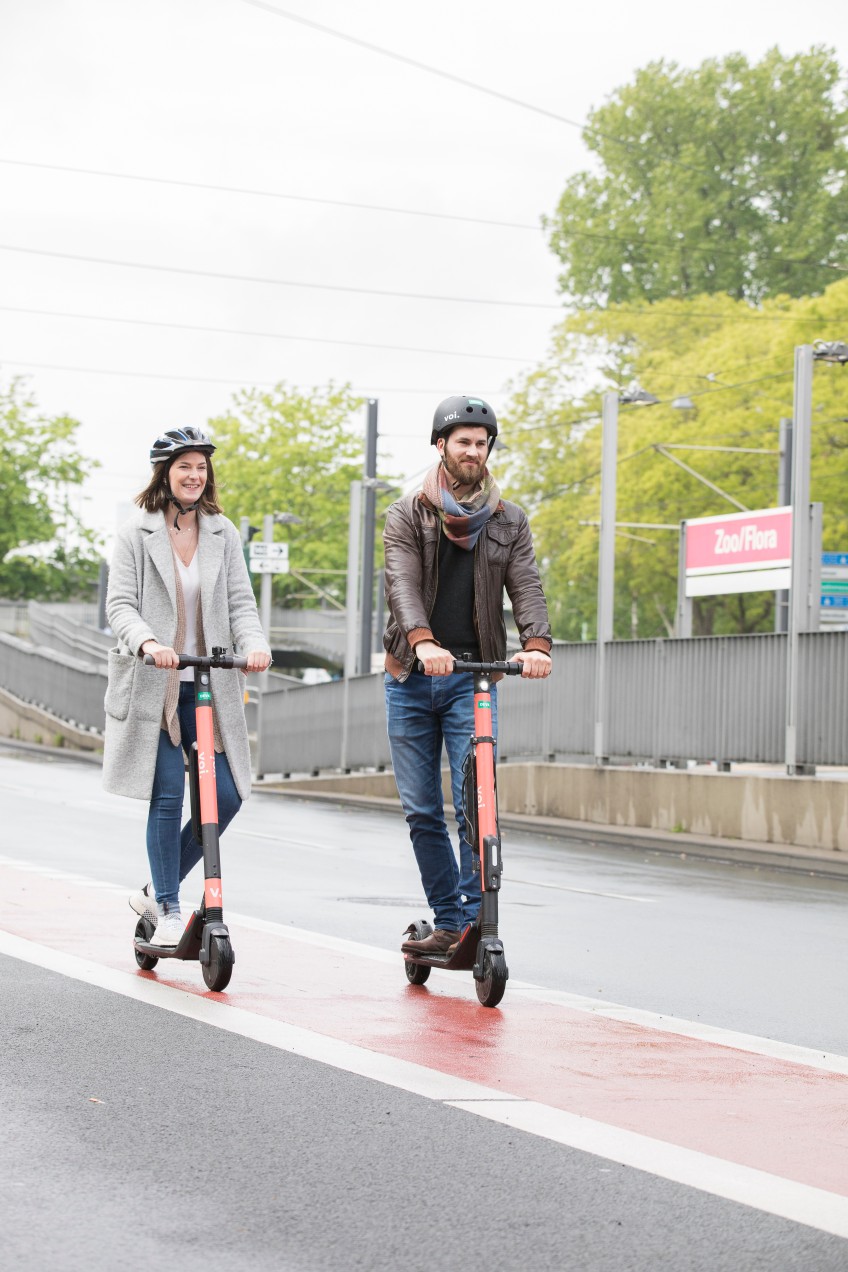 Pressemitteilung Moped-Autos: Mann und Frau mit E-Rollern auf dem Radweg