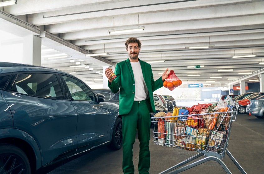 Pressemitteilung Umfrage Parkschäden: Mann mit Einkaufswagen vor Auto